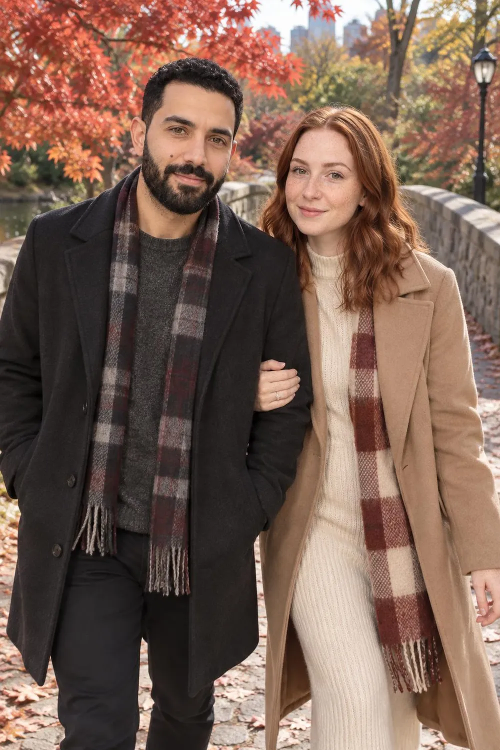 Engagement photo idea: couple walking across a stone bridge under red maples in a city park